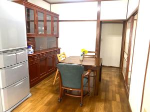 una cucina con tavolo e frigorifero di 鉄道と山の見える家 a Yufu