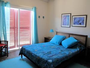 ユリューニュにあるApitoki - Chambres d'hôtes au Pays Basqueのベッドルーム1室(青いシーツと窓付)