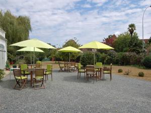 a group of tables and chairs with yellow umbrellas at La Maison d'Antan in Arzacq-Arraziguet