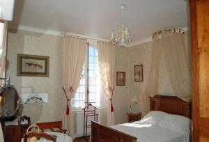 um quarto com uma cama e uma grande janela em La Maison d'Antan em Arzacq-Arraziguet