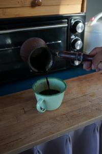 坎古的住宿－Kultur Umalas - CHSE Certified，把咖啡倒进柜台上的碗里的人