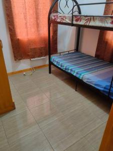 een kamer met 2 stapelbedden en een tegelvloer bij Sunmiles Condominium in Calamba
