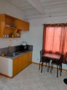 een keuken met een wastafel en een tafel en stoelen bij Sunmiles Condominium in Calamba