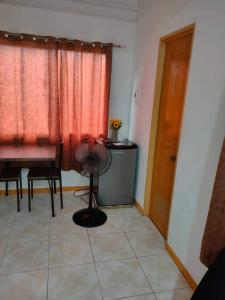 a room with a table and chairs and a red curtain at Sunmiles Condominium in Calamba