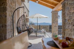 a patio with an umbrella and a table and a swing at Villa Poji in Buzet