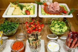 a table topped with different types of food in bowls at Hotel Bono in Budva