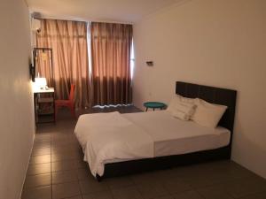 a bedroom with a bed and a table and a chair at G Star Motel in Kuching