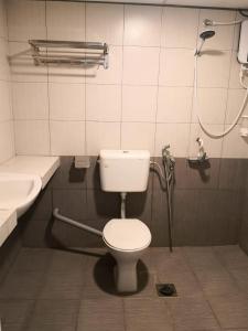 y baño con aseo, lavabo y ducha. en G Star Motel, en Kuching