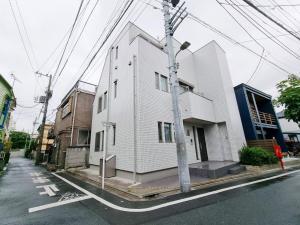 un edificio bianco sul lato di una strada di PRISM Inn Kamata a Tokyo