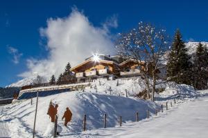 ein Haus auf einem schneebedeckten Berg in der Unterkunft Pension Tannenhof in Leogang