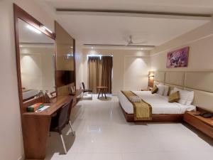 a hotel room with a bed and a desk at Hotel Tranquil Manipal in Manipal