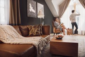 博希尼Boutique Hotel Sunrose 7 - Gourmet & SPA的坐在客厅椅子上的男女