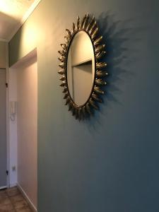 a mirror on a blue wall in a hallway at Studio Bee Home in De Haan