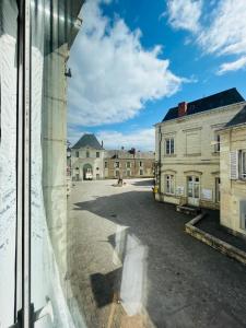 a view from a window of an empty street at Chez mimie les hôtes in Fontevraud-l'Abbaye