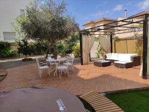 a patio with a table and chairs and a couch at Villa María, Piscina y Spa exterior privado in Belicena