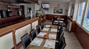 a dining room with a long table and chairs at Auberge aux Marais in Montmartin-en-Graignes