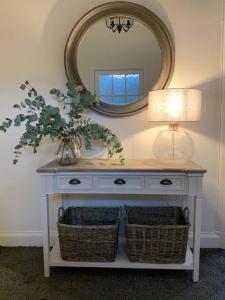 a white dressing table with a mirror and a lamp at Lovely 3 bedroom family friendly cottage in North Berwick in North Berwick