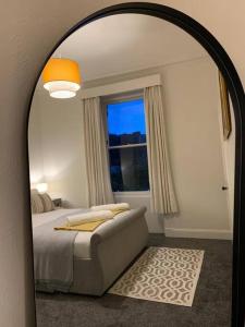 a mirror in a bedroom with a bed and a window at Lovely 3 bedroom family friendly cottage in North Berwick in North Berwick