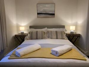 ein Schlafzimmer mit einem Bett mit zwei Kissen darauf in der Unterkunft Lovely 3 bedroom family friendly cottage in North Berwick in North Berwick