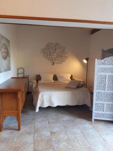 a bedroom with a bed with a tree on the wall at Gîte Acellu in Bonifacio