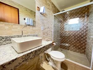 a bathroom with a sink and a toilet and a shower at Pousada Vila do Sol Corumbau in Corumbau