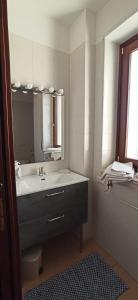 y baño con lavabo y espejo. en Attico Oleandro - Penthouse loft with sea view - Nova Siri, Basilicata, en Nova Siri Marina
