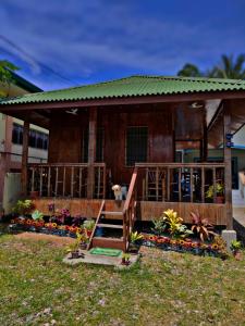 a house with a porch and a dog standing on the porch at Puerto Galera Transient Kubo Guest Place in Puerto Galera