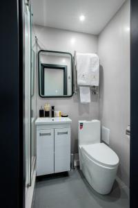 La salle de bains est pourvue de toilettes, d'un lavabo et d'un miroir. dans l'établissement Hotel Irtysh, à Öskemen