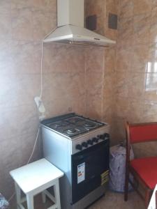 a stove in a small kitchen with a red chair at Apartament Nicoleta in Jurilovca +6 photos