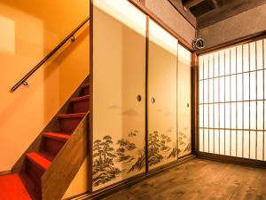 un pasillo con escaleras y una pared con un mural en Kyoto Miyabi Inn, en Kioto