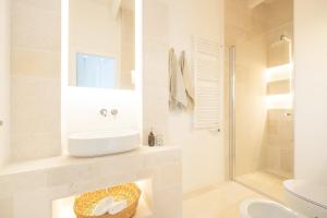 La salle de bains blanche est pourvue d'un lavabo et d'une douche. dans l'établissement Tra Cielo e Mare, à Vieste
