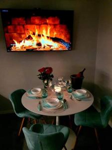 a table with plates and flowers and a fireplace at Horizon Park Carlo Rossi in Dziwnówek