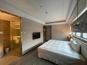a bedroom with a bed and a shower and a television at Royal Fine Hotel in Kaohsiung