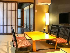 um quarto com uma mesa e duas cadeiras e uma televisão em Kyoto Miyabi Inn em Quioto