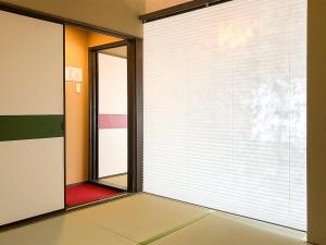 Habitación vacía con ventana grande con persianas en Kyoto Miyabi Inn, en Kioto