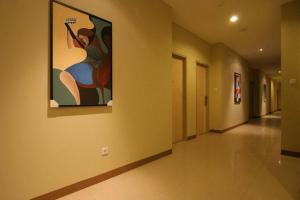 a hallway with a painting of a woman on the wall at Hotel Marlin Pekalongan in Pekalongan