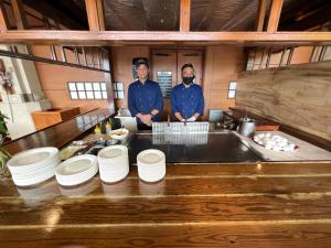 two men are standing in a kitchen with plates at Sea Passion Hotel in Koror +200 photos