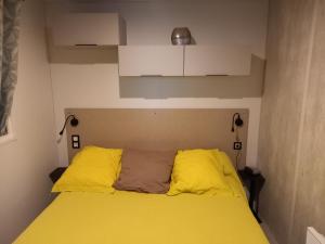 a bedroom with a yellow bed with two lamps at Mobil home yves et magali in La Garde-Freinet