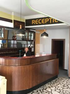 a woman sitting at the bar of a restaurant at Hotel Hefaistos - Sovata in Sovata