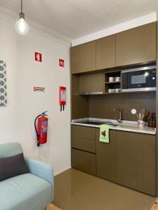 una cocina con fregadero y un sofá en una habitación en Sweet Love Family IV, en Coímbra