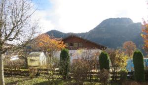 a house in the mountains with a fence and trees at Bergsonnenblick Bad Hindelang in Bad Hindelang