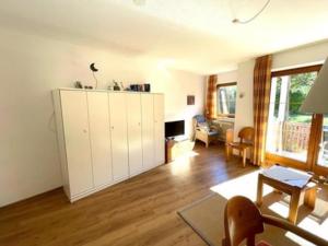 a living room with a large white cabinet at Bergsonnenblick Bad Hindelang in Bad Hindelang