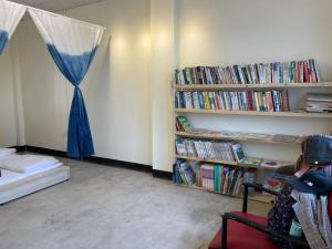 a room with a bed and a book shelf filled with books at Wanluan Organic Bookstore in Wanluan