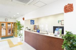 石垣島にあるホテルピースアイランド石垣イン八島の鉢植えのオフィスロビー(フロントデスクあり)