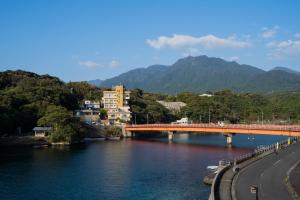 un ponte su un fiume accanto a una strada di Hotel Yakushima Sanso a Yakushima