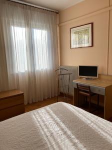 1 dormitorio con 1 cama y escritorio con ordenador en Tencarola B & B, en Tencarola