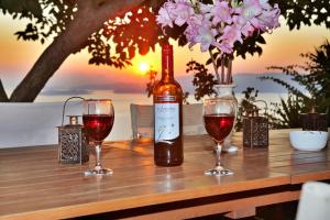 a bottle of wine and two glasses on a table at Villa Maria O in Skopelos Town