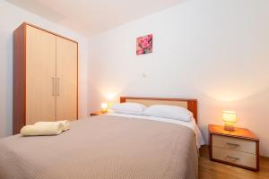 a bedroom with a bed and a dresser with two lamps at Haus Marija Brovinje in Koromačno +8 photos