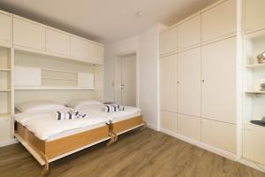 Schlafzimmer mit weißen Schränken und einem Bett in der Unterkunft Hüs Auert Tharep, Wohnung 2 in Hörnum