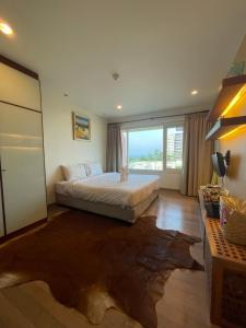 Un dormitorio con una cama y una ventana grande. en My Mykonos มายมิโคนอส, en Hua Hin